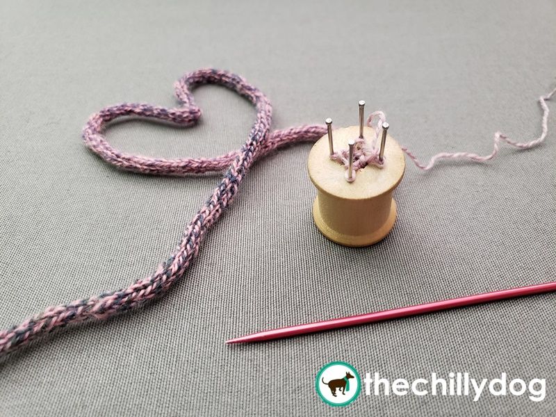 Knitting an i-cord with a wooden spool knitter.